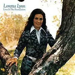 photo of Loretta Lynn standing with tree limbs