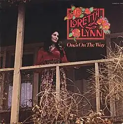 photo of Loretta Lynn standing on porch