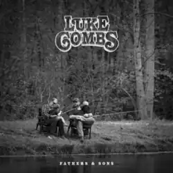 A black-and-white photograph of Luke Combs and his father sitting on chairs next to a creek fishing.