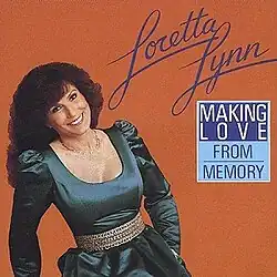 photo of Loretta Lynn smiling in blue dress on orange background