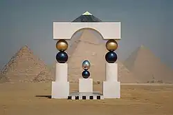 A portal made of white, black and gold marble at the desert, with the Giza Pyramids as its backdrop