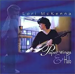 photo of Lori McKenna with guitar looking out window on blue background with soft image of child wearing angel wings and halo