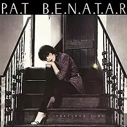 photo of Pat Benatar sitting with her hands and chin on her knee, seated on stairs leading toward a half-open door