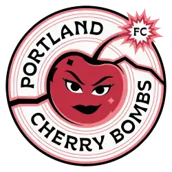 A red, pink, and black on white circular crest depicting a cherry with its stem replaced by a lit bomb fuse.