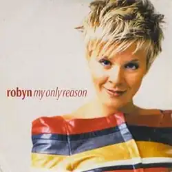 An image of a woman smiling and wearing a colorful top. The names of the single and the artist are superimposed over the image.