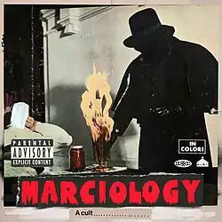 A cover in the style of a weather photograph or film poster with a man covered entirely in black clothing gripping an object that is on fire on a table