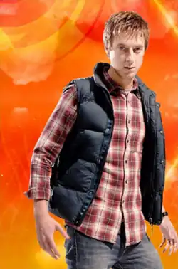 The blond Rory wears a black vest over a red checkered patterned shirt.
