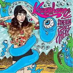 A brunette woman in a floral shirt with her hands on her head, surrounded by blue and green snake-like creatures. The text "Kreayshawn" and "Somethin' 'Bout Kreay" stand to her left.