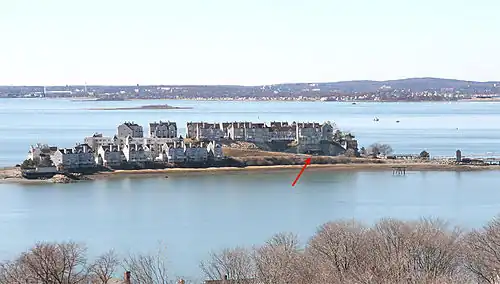 A 2010 view, looking westward at Hog Island, the site of Fort Duvall. Later the site was purchased, covered with condominiums, and renamed it Spinnaker Island. The arrow points to the casemate of Gun 2 of Battery Long, which is now a parking garage.