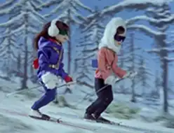 Two women skiing down a snowy slope.