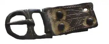 Boucle et chape de ceinture, fin du XIIe siècle et XIIIe siècle, bronze doré et décoré d'un blason de Lastours, découvert à Château Lastours en Aude en France.