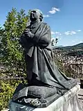 Statue de l'évêque, Auguste de Morlhon, au pied de la statue de la Vierge.