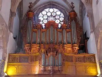 Photographie d'un orgue situé sur une tribune dans une église en grès.
