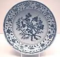 Plat de porcelaine de la dynastie Ming, avec un décor de branches d'arbre, de feuilles et une bordure florale