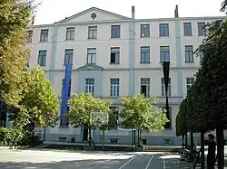 Vue d'ensemble d'un bâtiment scolaire à plusieurs étages, vu depuis la cour.