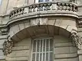 No&nbsp;64 : détail du balcon, montrant la date de construction de l'immeuble.