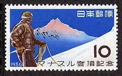 Timbre avec dessin stylisé d'un alpiniste sur fond de montagne enneigée, avec des indications en japonais, une valeur facile de 10 yens et la date de 1956.