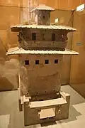 Maquette en céramique d'un entrepôt de stockage de grains avec des fenêtres et un balcon situé plusieurs étages au-dessus de la cour