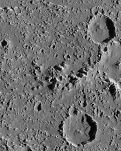 Vue de la surface, montrant de nombreux petits pics et deux larges cratères.