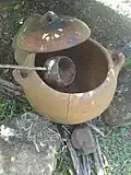 Reconstitution d'un feu de cuisine, devant la case. La louche est faite avec une calebasse