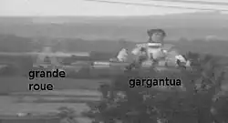 Photographie de deux attractions du parc, la grande roue et la statue gigantesque de Gargantua.