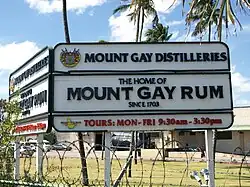 Photographie du panneau d'accueil situé à l'entrée du bâtiment indiquant que la distillerie Mount Gay est active depuis 1703