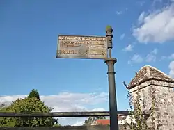 Ancien panneau de signalisation routière dans le village[23].