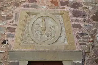 Linteau avec reliefs, armoiries avec cimier des barons de Grouvel (XIXe&nbsp;siècle).