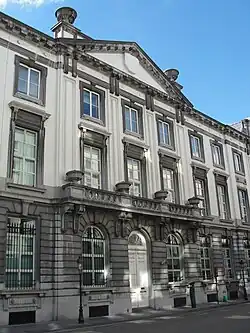 Entrée du bâtiment de trois étages, avec fronton triangulaire, comportant au premier un balcon courant sur 3 travées de hautes fenêtres.