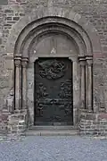 Chapiteau roman à l'Homme vert du portail sud (vers 1150) et bas-reliefs en bronze de Valdemar Grzimek (1972 et 1976)