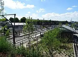 Vue d'ensemble de la gare avec les voies du T11, de la Grande Ceinture et les deux bâtiments voyageurs.