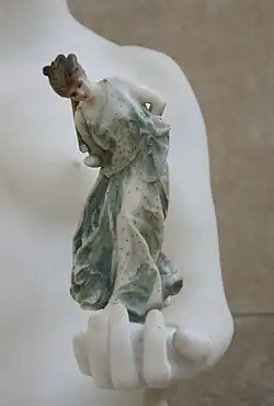 Gros plan sur la Danseuse au cerceau, polychrome endommagée dans la main de Tanagra, musée d'Orsay.