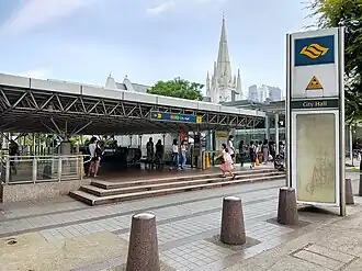 Photographie de l'entrée de la gare au niveau du sol, avec la cathédrale Saint-André en arrière-plan
