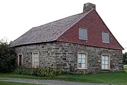 une maison en pierre avec un toit en bardeau de bois