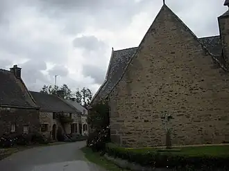 Le transept nord est en retrait du chevet. La croix monolithe porte un christ sculpté (XIVe&nbsp;siècle).