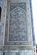Paroi latérale du pishtak de la médersa Tilla-Qari (inscriptions style bannaï).