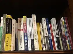 Tranches de livres alignés sur une étagère de bibliothèque.