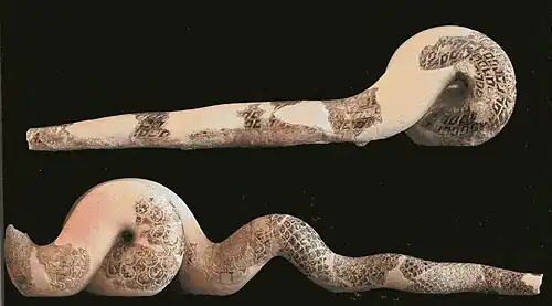 Corps de serpents, aux coins droit et gauche du fronton est.