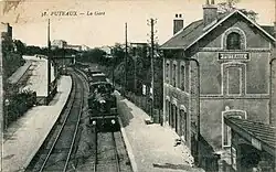 Un train à vapeur arrivant devant l'ancien bâtiment voyageurs, au début des années 1900.