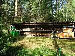 Ruches en lisière de la forêt (de gauche à droite) : rayons modernes en plastique, « paniers Kanitz », Ruche en cloche traditionnelle et ruche en bois.