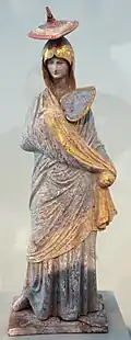 Figurine de Tanagra, Béotie. Terre cuite peinte et dorée, 325-300. Altes Museum, Berlin[N 17]