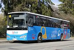 Photographie en couleurs d’un autocar bleu, blanc et noir vu de face.