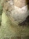 Le pilier gothique repose sur un pierre tombale à croix fleuronnée du XIIIe&nbsp;siècle