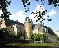 Photographie de l'extérieur d'un manoir entouré de douves.