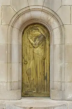Porte sculptée en bronze au centre du monument.