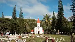 église en bois blanche entourée d'une pelouse, un cimetière se trouve à l'avantsur la gauche de la photo