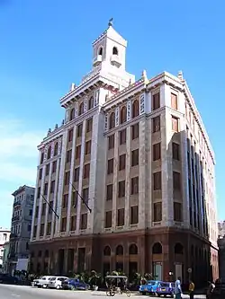 Un immeuble blanc surmonté d'une tour