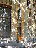 Façade aux étroites fenêtres et mur de verre haut de deux étages