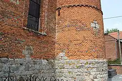 Détail du soubassement en grès et du mur de brique.