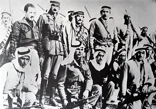 Abd al-Qader al-Husayni de retour en Palestine après dix ans d'exil, pour organiser la résistance arabe au plan de parution. Debout au centre, entouré d'aides de camp et de volontaires.Sous-district de Jérusalem, février 1948.